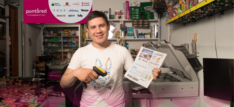 Una persona en una tienda sonríe mientras apunta un escáner de código de barras a una hoja impresa. Al fondo se ven estanterías con diversos productos.